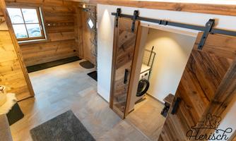 An inviting entrance area with wooden paneling and modern sliding doors. The room is bright and cozily designed.