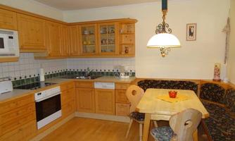 A cozy kitchen with bright wooden cabinets and a dining table. The rooms are well structured and tastefully furnished.