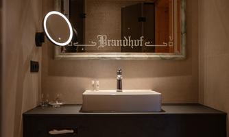 A modern bathroom with an elegant sink and mirror. The lighting is subtle and creates a pleasant atmosphere.