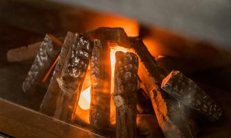 A cozy fire in a fireplace with logs. The flames glow warmly and create an inviting atmosphere.