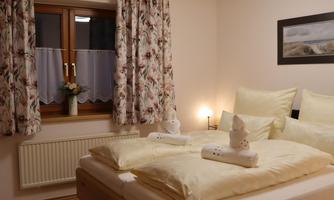 A cozy bedroom with a large bed and comfortable pillows. The warm colors and decor create an inviting atmosphere.