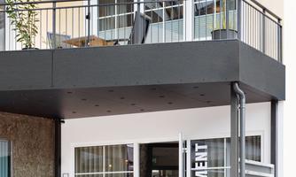 A modern apartment with a balcony and a sunshade. The entrance door is welcoming and well-designed.