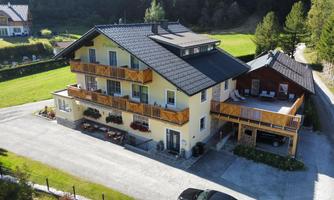 A modern building with multiple floors and beautiful balconies. It is located in a quiet, green environment.