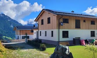 Beautiful houses in a picturesque mountain landscape. The sun is shining and the sky is blue with a few clouds.