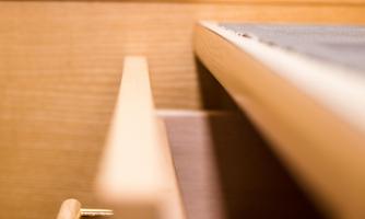 A half-open wooden drawer is visible. The wood grain and simplicity of the design appear modern and elegant.