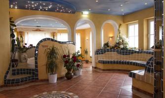 An inviting reception area with colorful tiles and plants. The walls are painted in warm colors, radiating a cozy atmosphere.