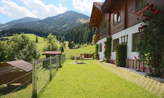 A charming house nestled amid green meadows and mountains. The garden is well-kept and invites relaxation.