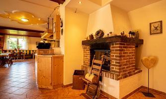 A cozy living space with a brick and wood fireplace. The furnished room features warm colors and an inviting atmosphere.