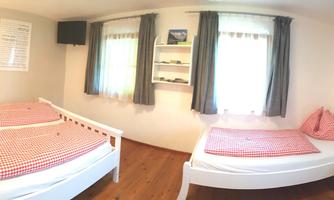 A bright room with two sleeping places and soft pillows. Large windows provide plenty of daylight.