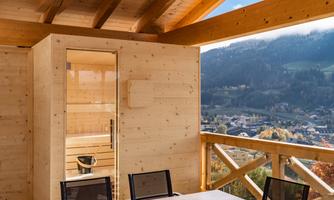 A cozy room with a sauna and a view of the mountains. Large windows let in plenty of natural light.