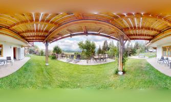 A beautiful outdoor area with a green lawn and several seating options. In the background, there are trees and a gentle landscape.