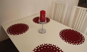 A beautifully decorated table with red placemats and a red candle in the center. The surroundings are bright and modern.