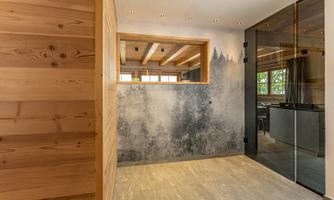 A modern room with wooden paneling and a painting depicting a forest. Large windows provide plenty of daylight.