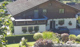 A charming house in Alpine style with a beautiful garden. The surroundings are green and inviting.
