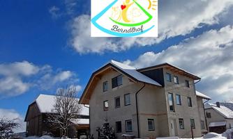 The Berndlhof in winter with the logo of Berndlhof displayed above.