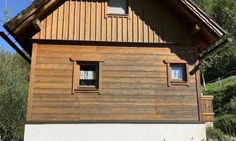 A charming wooden house in a rural setting. The clear sky and green landscape give the picture an idyllic atmosphere.