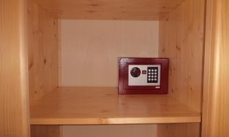 An empty wooden shelf with a small red safety treasure chest in the middle. The surroundings are simple and unobtrusive.