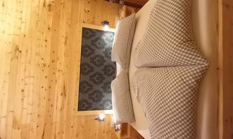 Our Swiss stone pine room provides all guests with a peaceful sleep! The pillows have a checkered pattern and the walls feature a decorative accent.