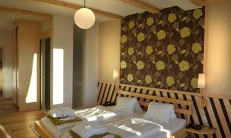 A modern bedroom with a double bed and wooden accents. The walls are decorated with a floral pattern and the lighting is warm and inviting.
