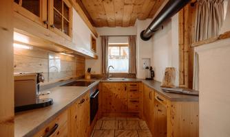 A modern wooden kitchen with elegant surfaces.  
Plenty of light flows through the window, creating an inviting atmosphere.