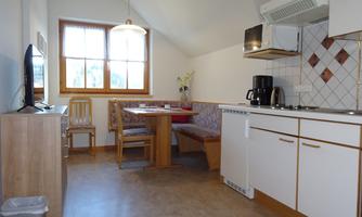 A cozy kitchen with a dining area and a modern stove. The window provides enough daylight and a pleasant atmosphere.
