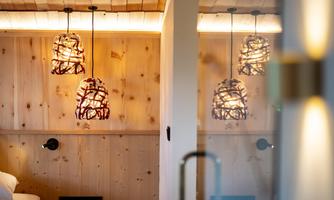 A stylish interior with wooden paneling and modern lamps. The warm lights create an inviting atmosphere.