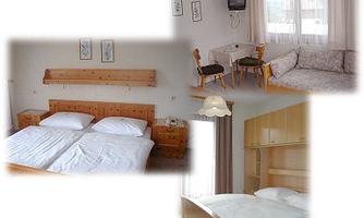 A cozy hotel room with a double bed, a table, and a sofa. Bright colors and large windows create an inviting atmosphere.