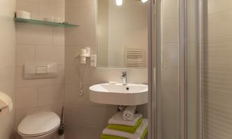The Alina-Chiara apartment features two separate bathrooms, each equipped with a sink, shower, and toilet.