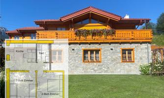 A beautiful house with wooden cladding and a terrace. In the foreground, there is a floor plan of the house visible.