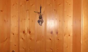 A wooden front door with the number 3. Above the door hangs a large keychain.