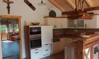 A modern kitchen with bright furniture and wooden details. There is an open layout with plenty of natural light.