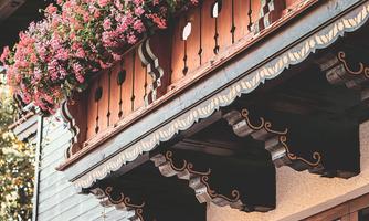 A beautifully decorated balcony with many colorful flowers. The wood design and the plants give the house a charming, rustic character.