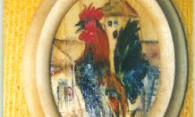 A painted picture of a rooster in an oval frame. The background is in warm colors, giving the picture a friendly atmosphere.