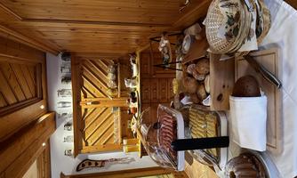 An inviting breakfast buffet in a wood-paneled room. There is a selection of cold cuts, breads, and pastries.