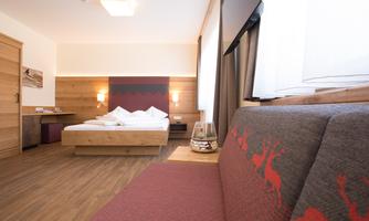 A cozy hotel room with wooden décor and a modern design. The room features a large bed and an inviting seating area.