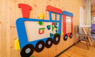 A colorful wall design in the shape of a train, ideal for children. The train includes various play and learning elements.