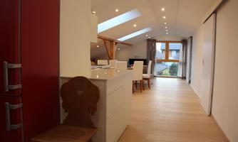 A modern and bright apartment with wooden floors. The kitchen is open and offers plenty of natural light through the skylights.