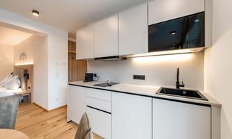 A modern kitchen with white cabinets and sleek appliances. The space is bright and inviting.