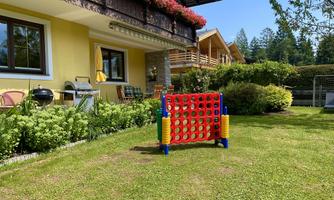 A beautiful garden with green grass and colorful play equipment. In the background, houses and trees can be seen.