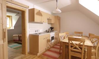 A cozy kitchen with a dining table and chairs. The room is bright and has a modern, friendly design.