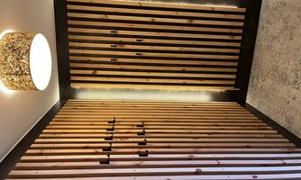 A modern designed hallway with vertical wooden panels and hooks. The ceiling light provides pleasant illumination.
