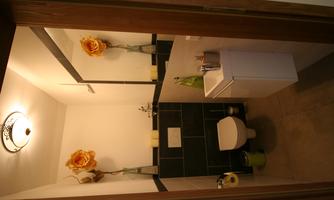A small, elegant bathroom with modern tiles. It is brightly lit and tastefully decorated.