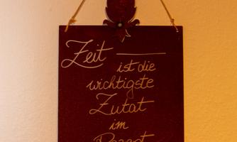 A decorative sign hangs on the wall. It says: "Time is the most important ingredient in the recipe of life."