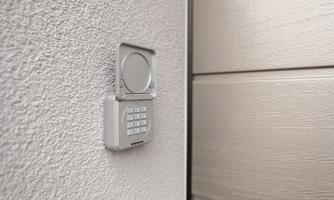 A modern access control button on a wall. Next to it, a closed door is visible.