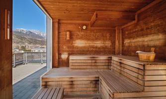 A cozy sauna area made of wood with a view of the mountains. Large windows let in plenty of light and provide a relaxing atmosphere.