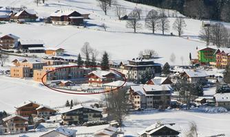 A picturesque village in the snow with several traditional houses. The surroundings are surrounded by snow-covered hills.