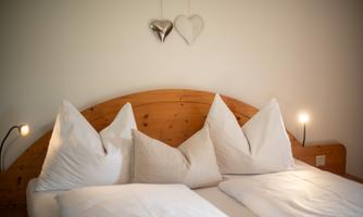 A cozy bedroom with a large double bed and elegant pillows.