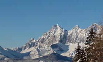An impressive mountain panorama with snow-capped peaks. The clear blue sky completes the beautiful winter landscape.