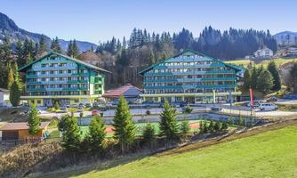 A modern hotel building in a picturesque landscape.  
Surrounded by green meadows and mountains, the surroundings exude tranquility and relaxation.