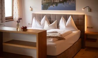 A cozy bedroom with a large bed and direct views of the Dachstein.